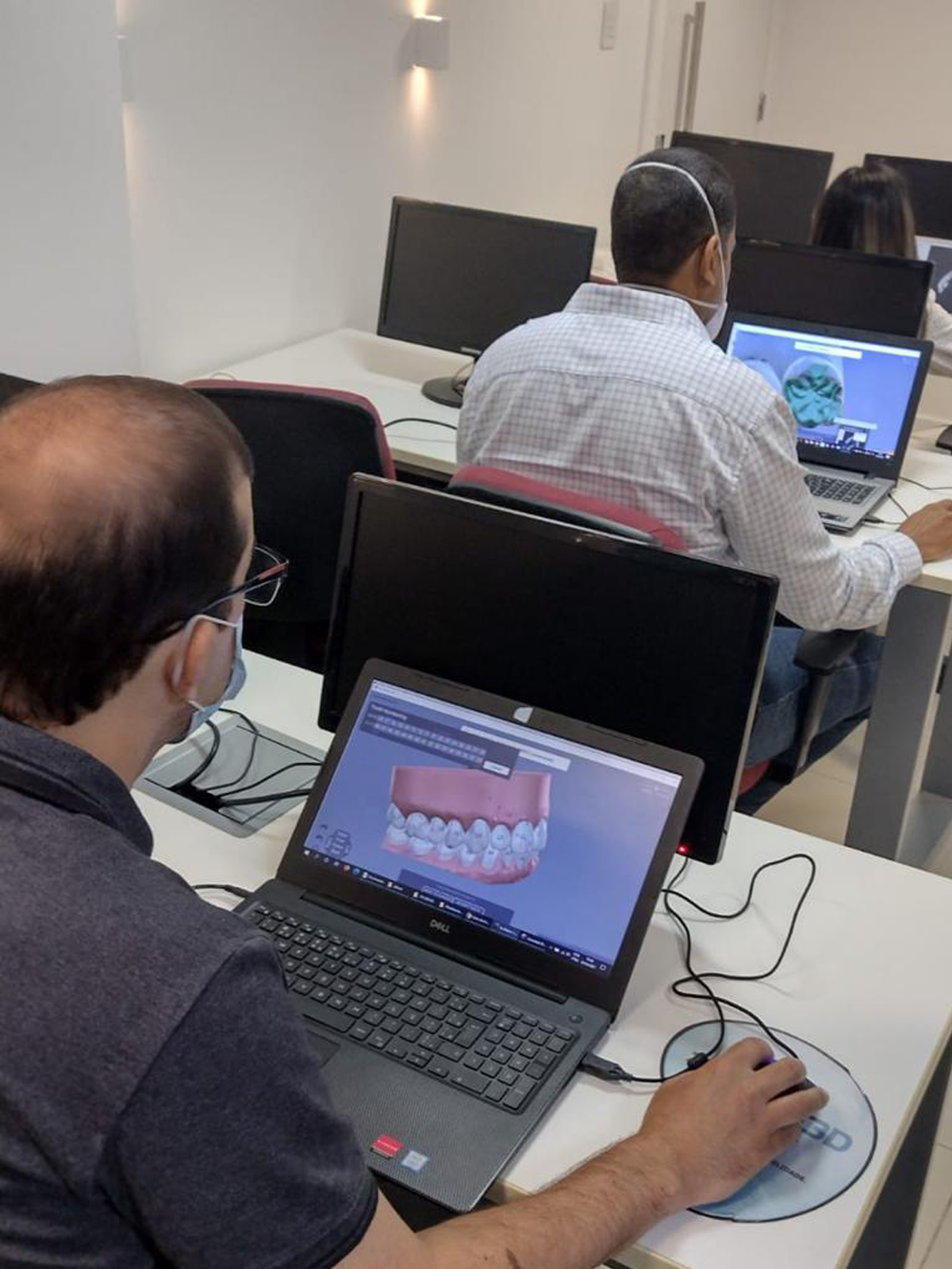 Alunos aprendendo software de planejamento ortodôntico